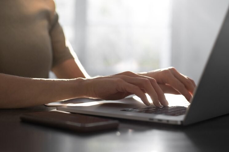 Woman typing email on laptop